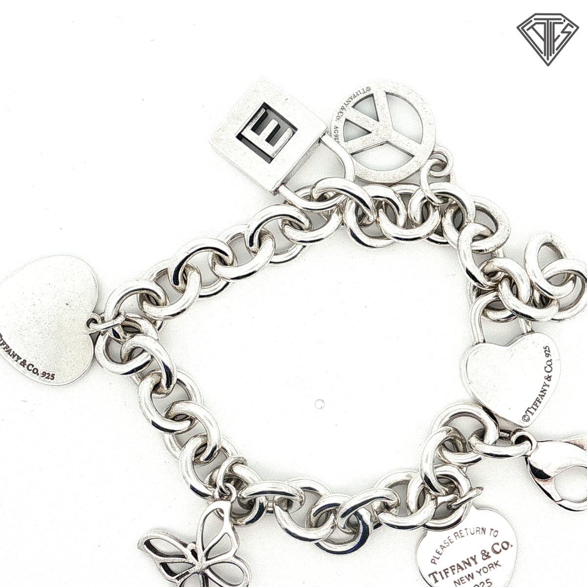 Pre-Loved Tiffany & Co. Sterling Silver Return to Tiffany Heart Tag Charm Bracelet with Butterfly Charm, Beaded Heart "Mom" Charm, Letter E Pad Lock, Peace Sign, Heart Pad Lock Charm Bracelet 61.7 gram  7.5 inch