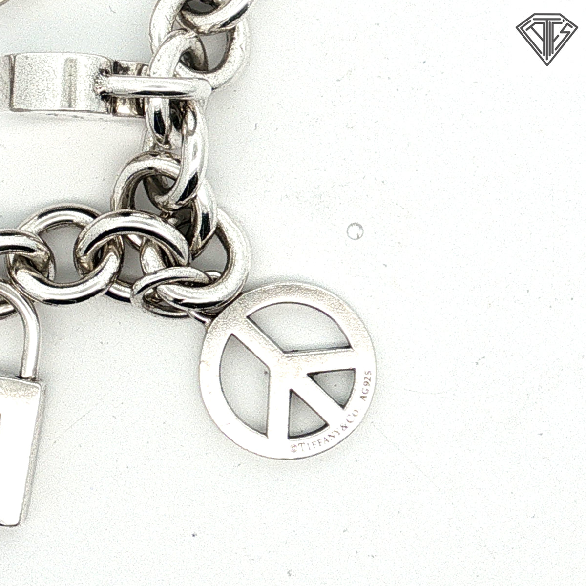 Pre-Loved Tiffany & Co. Sterling Silver Return to Tiffany Heart Tag Charm Bracelet with Butterfly Charm, Beaded Heart "Mom" Charm, Letter E Pad Lock, Peace Sign, Heart Pad Lock Charm Bracelet 61.7 gram  7.5 inch
